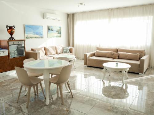 a living room with a couch and a table and chairs at Golden Gate 21 in Ruma
