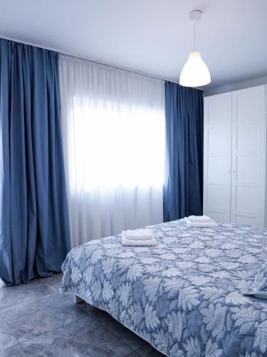 a bedroom with a large bed with blue curtains at Golden Gate 21 in Ruma