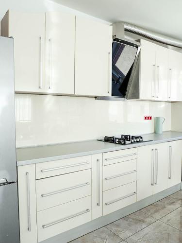 a kitchen with white cabinets and a counter top at Golden Gate 21 in Ruma