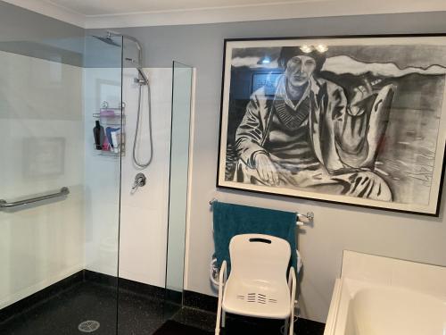 a bathroom with a painting of a man on the wall at Art House Blue Room in Huonville