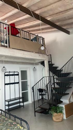 a living room with a staircase and a table and chairs at Casa Cibella Authentic Charme Apartments in Agrigento