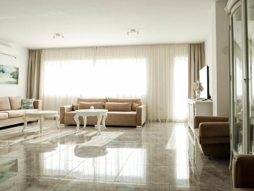 a living room with a couch and a table at Golden Gate 21 in Ruma