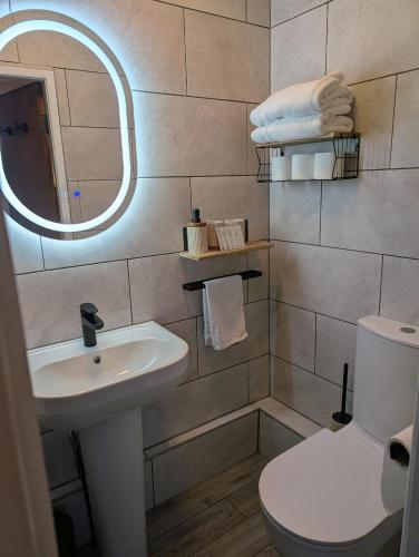 a bathroom with a sink and a toilet and a mirror at Hesketh Hotel in Blackpool