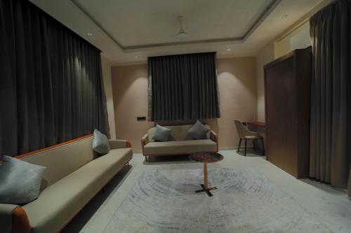 a living room with a couch and a table at Hotel Aishwarya in Akalkot