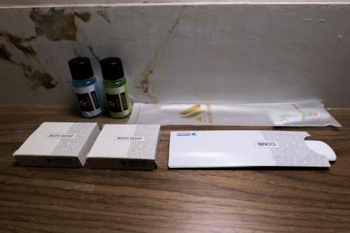 a wooden table with two bottles of essential oils and towels at Hotel Aishwarya in Akalkot