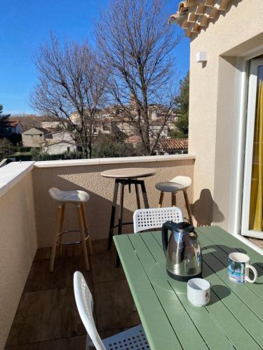 a green table and chairs on a balcony at Maison à Sablet in Sablet