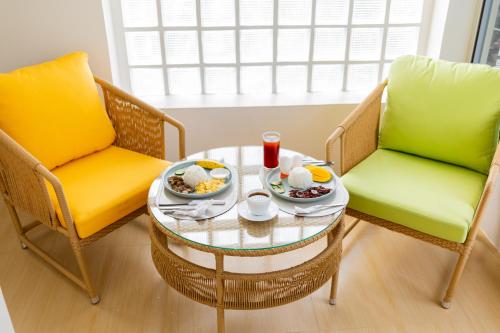 two chairs and a coffee table with food on it at Anahaw Seaside Inn in Bantayan Island