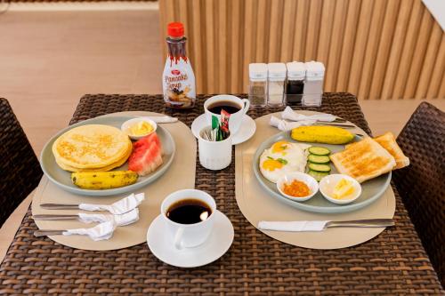 a breakfast of eggs and fruit and coffee on a table at Anahaw Seaside Inn in Bantayan Island