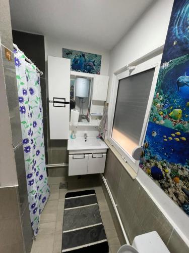 a bathroom with a sink and a fish painting on the wall at Villa Taraxha in Mitrovica