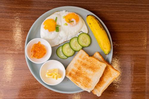 a plate of breakfast food with eggs and toast at Anahaw Seaside Inn in Bantayan Island