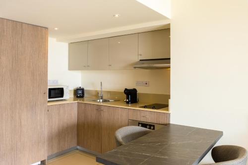 a kitchen with a table and a microwave at Melpo Antia Hotel & Suites in Ayia Napa