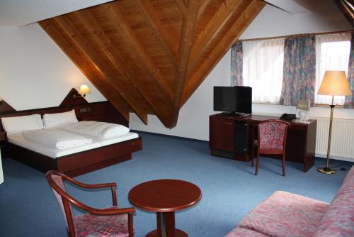 a hotel room with a bed and a table and chair at Hotel Waldhorn in Friedrichshafen