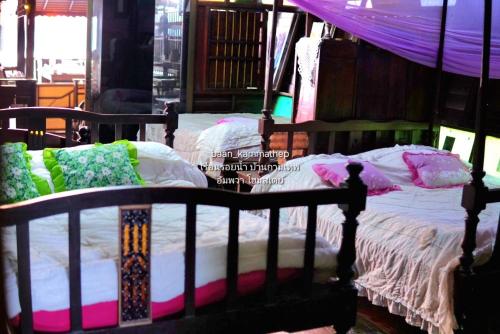 a bedroom with two beds with pillows on them at p5 เรือนในฝัน เรือนรอยน้ำ บ้านกามเทพ อัมพวา โฮมสเตย์ in Ban Wat Bot