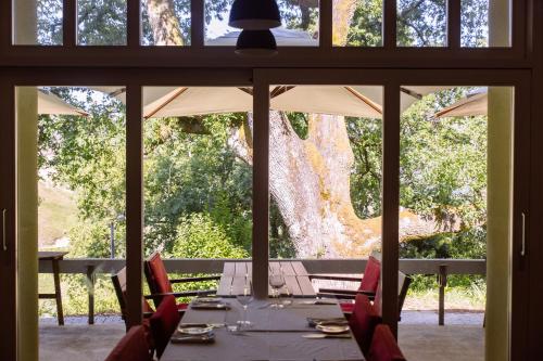 a dining room with a table and chairs and a tree at Hotel Rural Misarela in Geres
