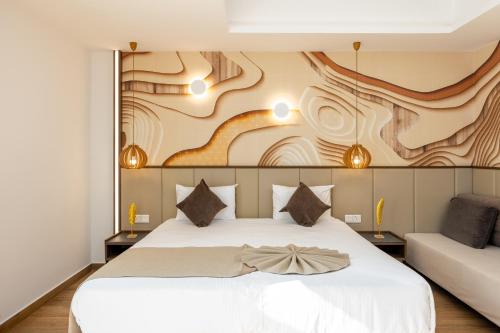 a bedroom with a white bed with a painting on the wall at Melpo Antia Hotel & Suites in Ayia Napa