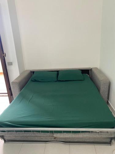 a bed with a green mattress in a room at Appartamento Smeraldo Pochi passi dal mare in Calasetta