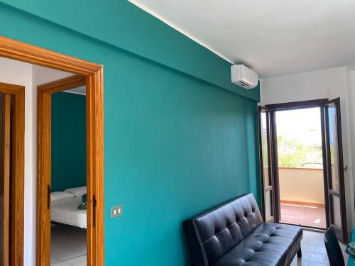 a living room with a couch and a blue wall at Appartamento Smeraldo Pochi passi dal mare in Calasetta
