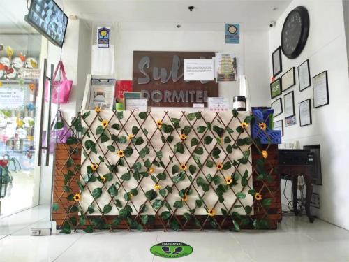 a wall with a bunch of wine bottles in a store at Sulit Budget Hotel VMapa in Manila