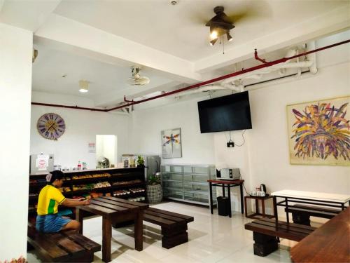 a person sitting at a table in a room at Sulit Budget Hotel VMapa in Manila
