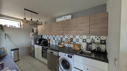 une cuisine avec un évier et une machine à laver dans l'établissement Superbe appartement quartier Timone, à Marseille
