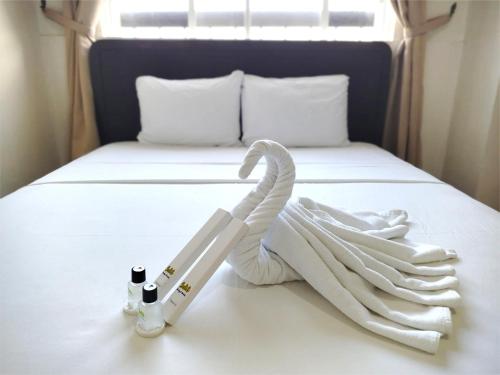 a bed with a towel and two bottles on it at Sulit Budget Hotel VMapa in Manila