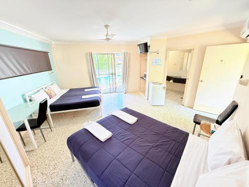 a room with a bed and a table and a couch at Emu Park Beach Resort in Emu Park