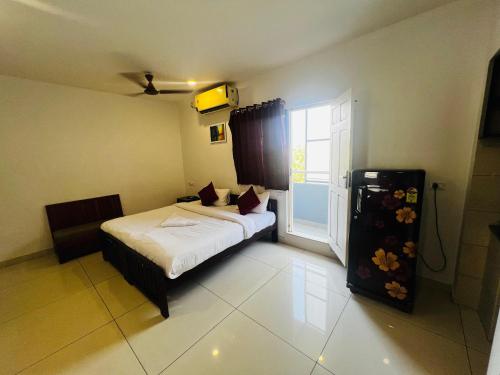 a small bedroom with a bed and a window at White House Inn in Ernakulam