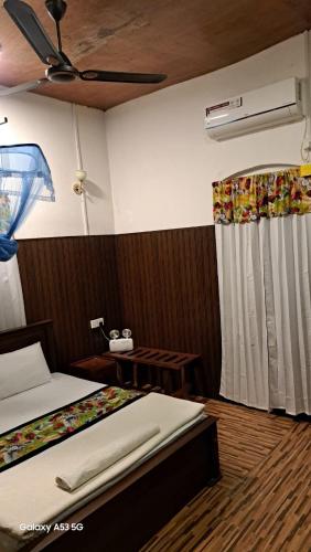 a bedroom with two beds and a ceiling fan at Arachiwil Green Nature Resort in Puttalam