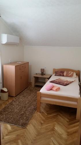 a bedroom with a bed and a wooden cabinet at Cicvaric rooms in Virpazar