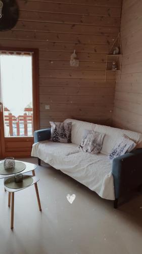 a living room with a white couch and a table at Le petit chalet de campagne in Richeling