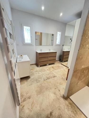 une salle de bain avec deux lavabos et un grand miroir dans l'établissement Large modern house near St Rémy de Provence, à Graveson