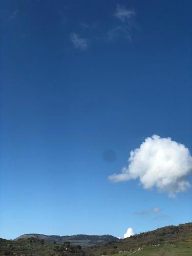 a blue sky with a cloud in a field at Albergo BELVEDERE in Santa Cristina Gela