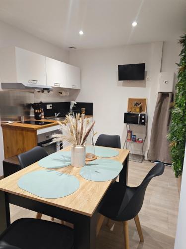 une cuisine et une salle à manger avec une table et des chaises en bois dans l'établissement La grange des 3 colibris, à Écueillé