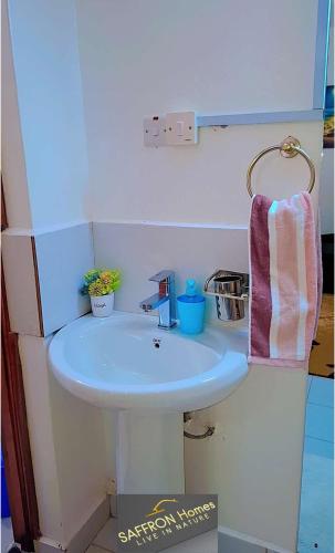 a small bathroom with a sink and a towel at Saffron Homes in Eldoret