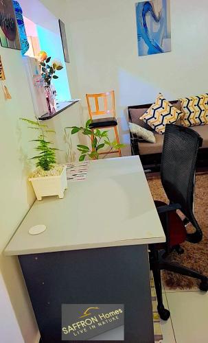 a white desk with two chairs and a couch at Saffron Homes in Eldoret