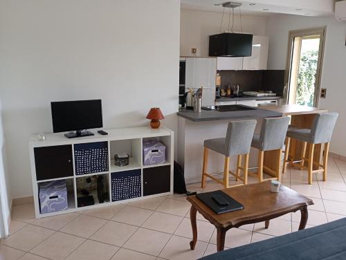 un salon avec une table et une cuisine dans l'établissement Appartement lumineux avec terrasse de 50m2, à Antibes