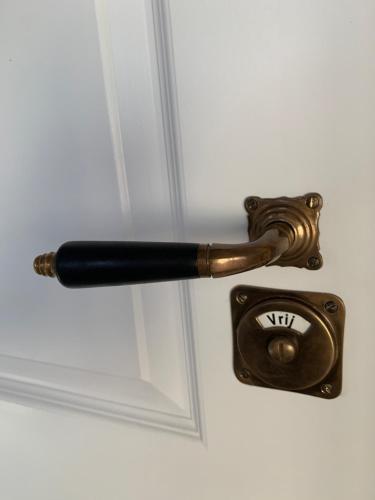 a bronze door handle with aigil on a white door at Vernieuwd luxe voorhuis - naast de molens in Groot-Ammers