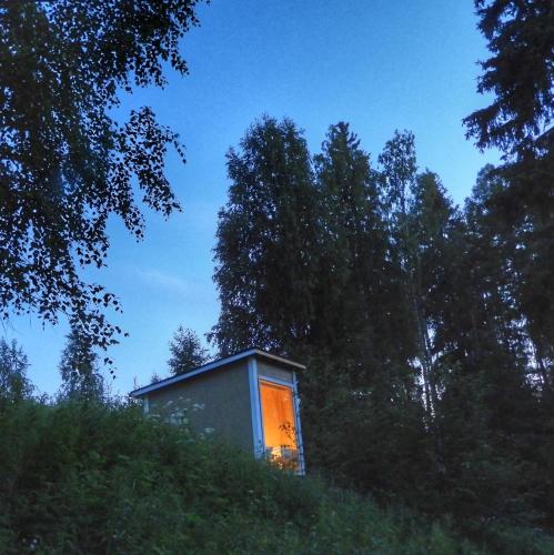 a small house on top of a hill with trees at KoloCabins - Hiitolanjoki 4 in Simpele