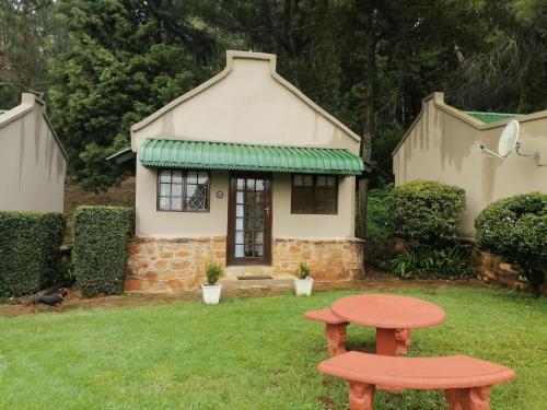 a small house with a bench in the yard at The Retreat Country Lodge in Romelcoh
