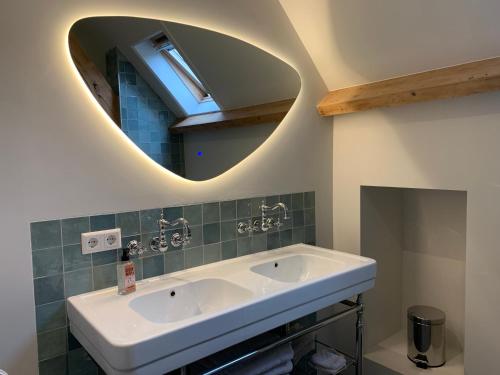 a bathroom with a sink and a mirror at Vernieuwd luxe voorhuis - naast de molens in Groot-Ammers