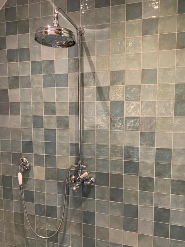 a shower with a shower head in a bathroom at Vernieuwd luxe voorhuis - naast de molens in Groot-Ammers