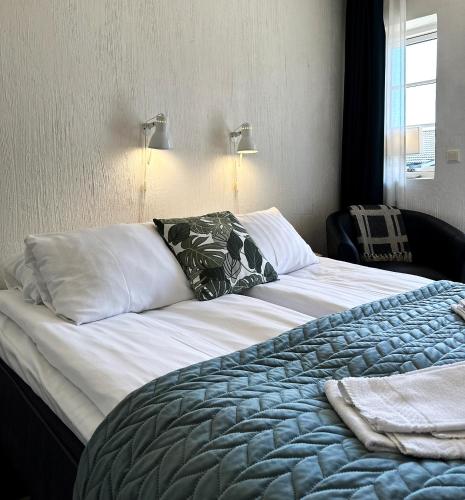 a bedroom with a large bed with white sheets and pillows at Villa Beddingestrand in Beddinge Strand