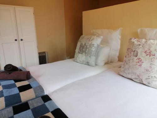 two beds with white sheets and pillows in a room at The Retreat Country Lodge in Romelcoh