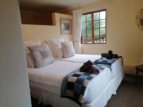two twin beds in a room with a window at The Retreat Country Lodge in Romelcoh