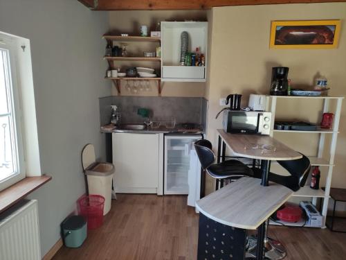une petite cuisine avec une table et un micro-ondes dans l'établissement Les Lodges Du Pavillon F2, à Molinges