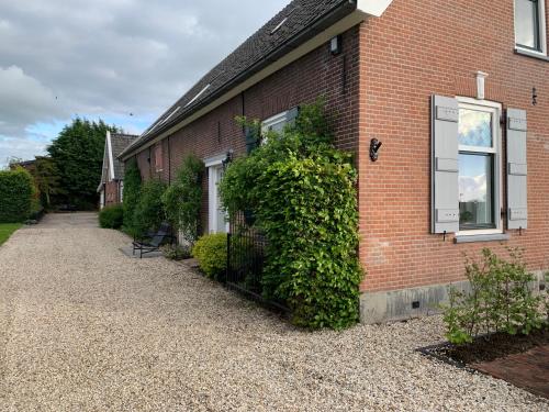 a brick house with ivy growing on the side of it at Vernieuwd luxe voorhuis - naast de molens in Groot-Ammers