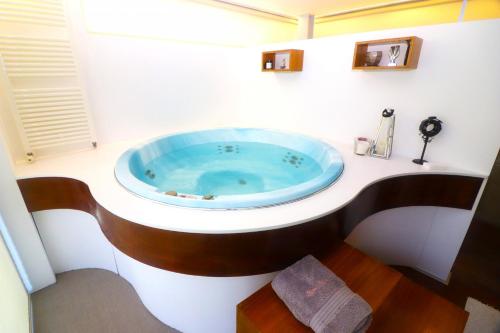 Un baño con una bañera azul en un lavabo. en Roque Village by Gerês Casas, en Vieira do Minho