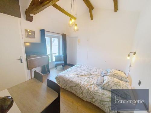 a bedroom with a bed and a table and a desk at Le Studio Augouard - Calme &Cosy in Poitiers