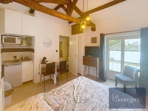 a bedroom with a bed and a kitchen with a table at Le Studio Augouard - Calme &Cosy in Poitiers