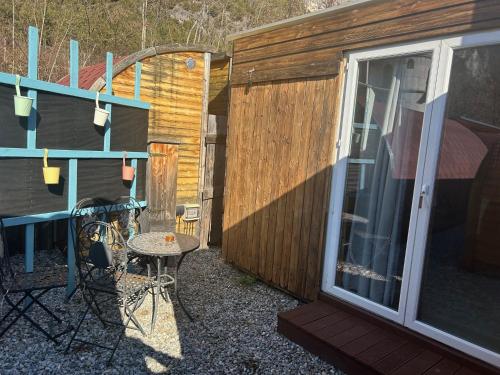a patio with a table and chairs next to a building at Inn-side ADVENTURE CABINS in Haiming
